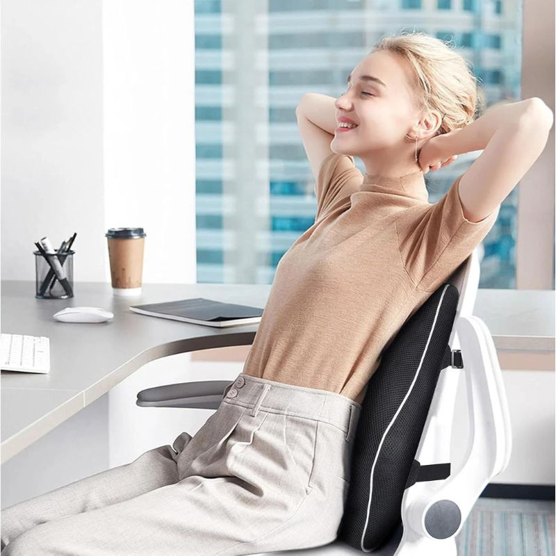 Femme détendue sur sa chaise de bureau, mains derrière la tête, dos soutenu par le coussin lombaire
