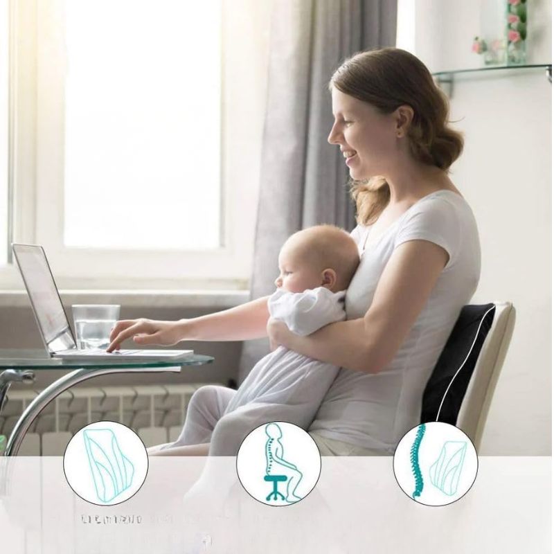Femme installée avec son bébé travaillant sur un ordinateur portable, dos soutenu par le coussin lombaire