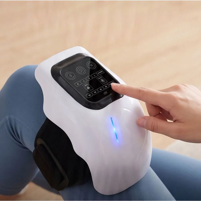 Doigt appuyant sur l'écran tactile de contrôle du masseur de genou