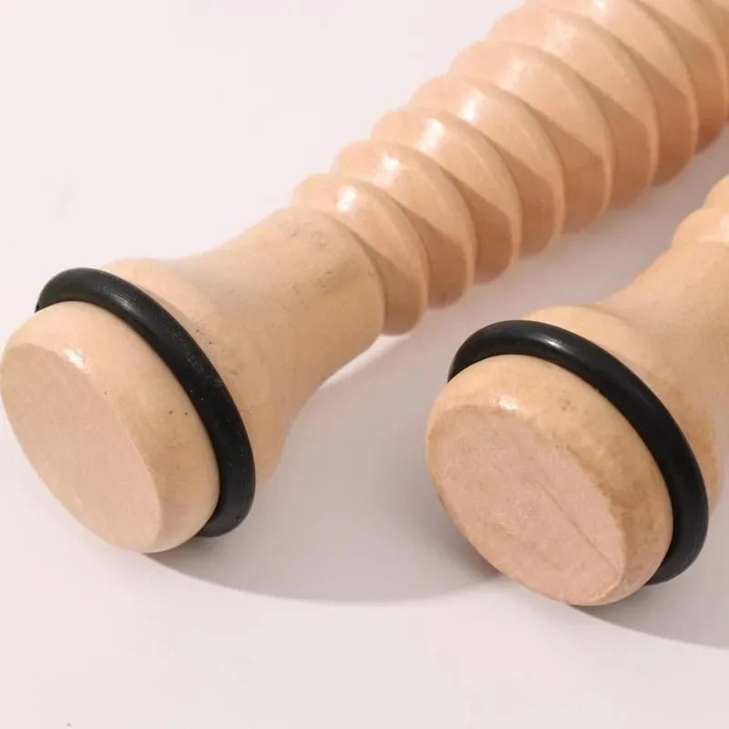 Gros plan sur les embouts arrondis en bois massif avec joint en caoutchouc du rouleau masseur