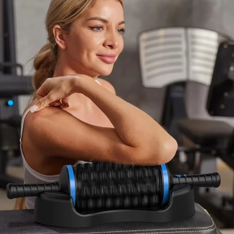 Femme en salle de sport utilisant le rouleau masseur à percussion 360° sur l'épaule après l'entraînement